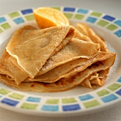 Several orange crepes on a plate