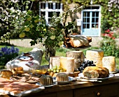 A buffet with old French cheese and ham in a summer garden
