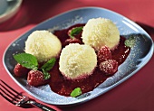 Coconut balls with raspberry sauce and fresh mint