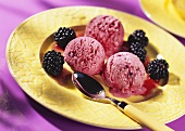 Blackberry ice cream with blackberries on yellow plate