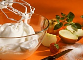 Whipped cream in glass dish, fresh fruit and sugar
