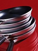 A pile of pans on red background