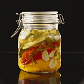 Bottled vegetables with herbs in preserving jar