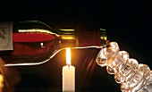 Filling carafe with red wine over candle flame