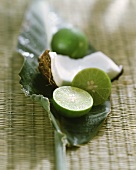 Lime halves and wedge of coconut on banana leaf