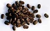 A heap of coffee beans on light background