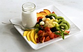 Fruit salad with a jar of yoghurt