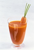 Carrot juice with peeled carrot in glass
