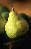 Green pears on wooden plate