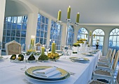 Hochzeitstafel mit gelben Blumen und lindgrünen Kerzen in klassischem Ambiente