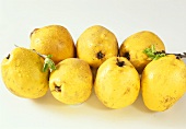 Several quinces with drops of water on white background