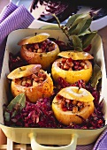 Red cabbage, ham-stuffed apples & bay leaf in a roasting dish