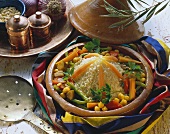 Couscous with vegetables in clay dish; pine nuts; garlic