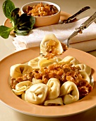 Tortellini with meat sauce on plate and fork above it