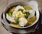 Cod cutlets with mustard sauce, lemons and parsley