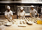 Baker forming loaves in a large bakery