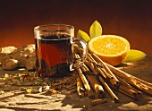 Mulled wine in glass, surrounded by ingredients