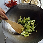 Frying spring onions in a wok
