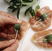 Attaching sage leaves to veal escalope