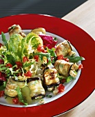 Aubergine rolls with mozzarella and rocks on salad leaves