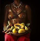 African woman holding exotic fruits in a bowl