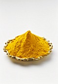 Turmeric powder on gold-coloured plate