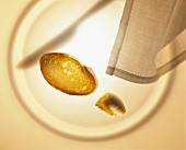 Baguette slice, butter curl, napkin and plate