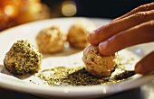 Rolling sausage forcemeat balls in crumbled herbs