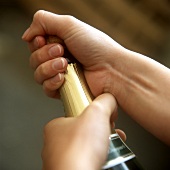 Opening sparkling wine bottle: holding cork firmly in hand