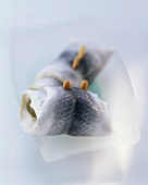 Two rollmops on a white dish