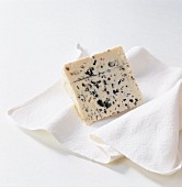 A piece of blue cheese on white cloth