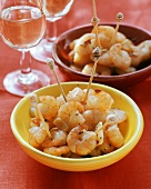 Garlic shrimps with cocktail sticks in bowls; white wine