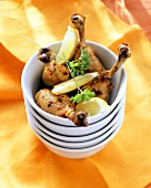 Marinated chicken legs with lemon wedges in bowl