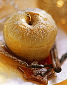 Ginger baked apples with icing sugar, caramel & cinnamon stick