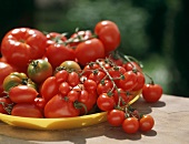 Various tomatoes on yellow plate on table