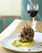Roast poussin on noodles; red wine glass