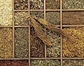 Various medicinal herbs, a ginseng root on top