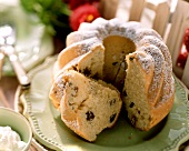 Gugelhupf with icing sugar and raisins, a piece    cut