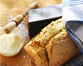 Madeira cake beside loaf tin; icing with pastry brush