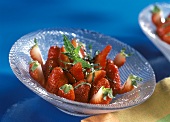 Marinated strawberries with fresh mint in glass bowl