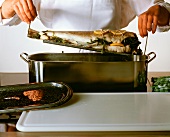 Placing stuffed cod into a fish kettle