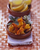 Shrimps with tomato and saffron sauce in terracotta bowl