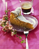 Piece of almond cake with icing sugar; pink flowers; coffee