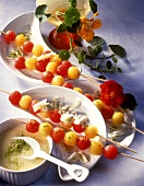 Melon kebabs with white chocolate sauce and pistachios