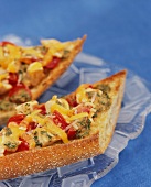 Toasted baguette pieces with chicken and tomatoes
