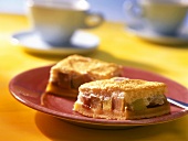 Pieces of rhubarb meringue cake on red plate