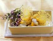 Steamed pineapple with coconut sauce and herb sprig