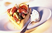 Piece of fig cake with a spoonful of cream