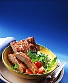 Spare-ribs with rocket and tomatoes