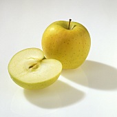 Whole and half a Golden Delicious apple